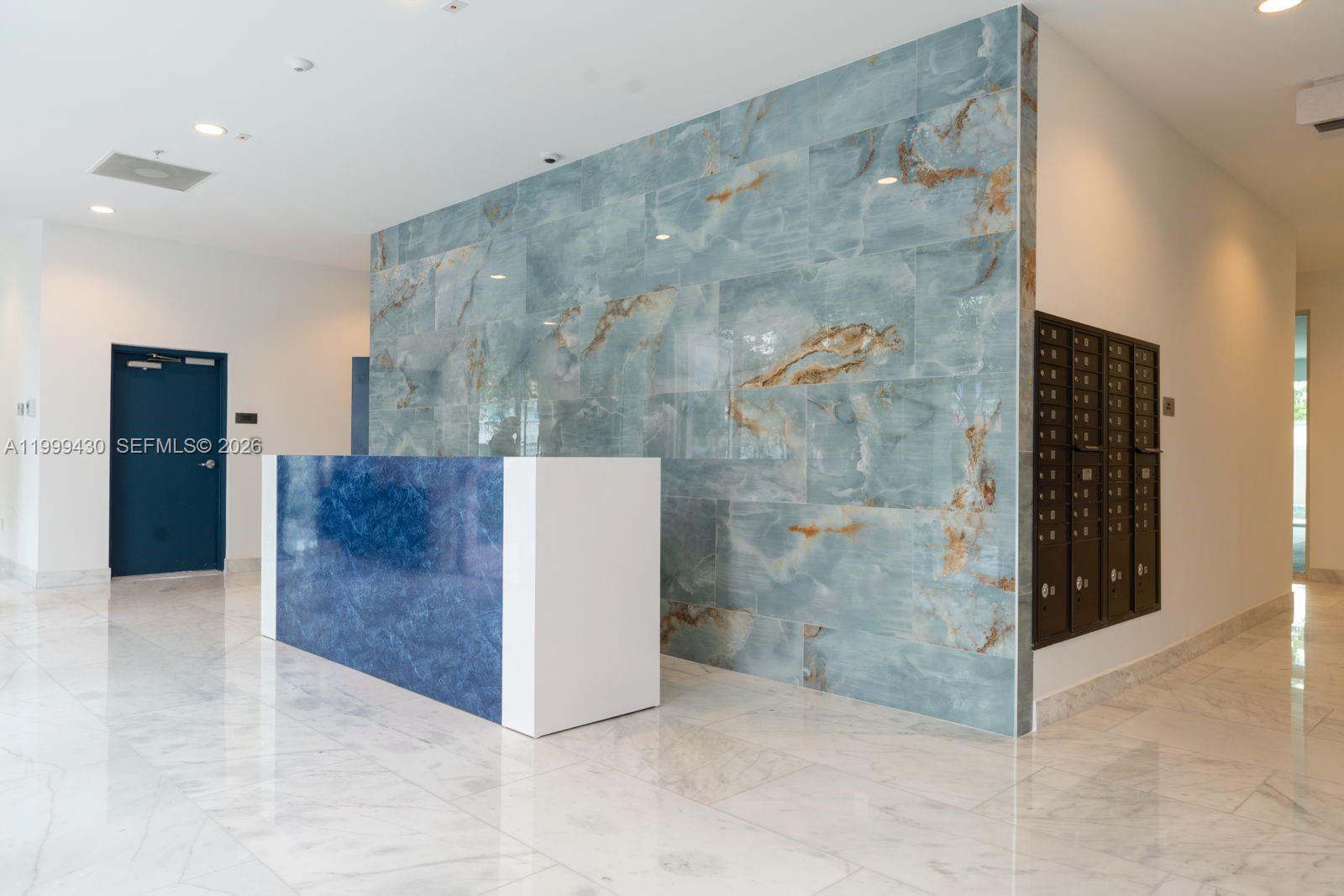 A lobby features a blue marble-style reception desk and a large blue-veined accent wall — 1850 Monroe St # 306, Hollywood FL 33020, HOLLYWOOD, FL