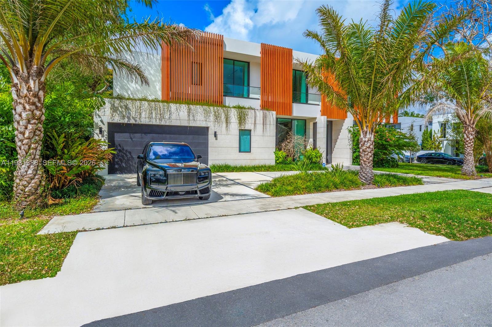 A modern white two-story house features a backyard with a swimming pool and lawn — 7700 SW 50th Ct, Miami FL 33143, MIAMI, FL