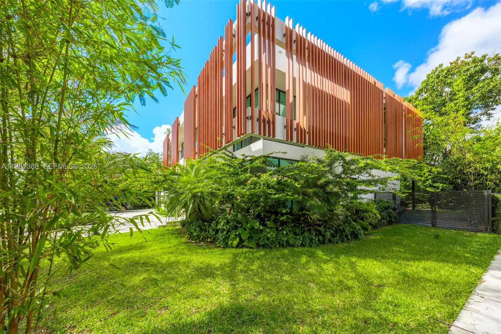 A modern open-concept living and dining area features light wood paneling, neutral furniture, and stairs — 7700 SW 50th Ct, Miami FL 33143, MIAMI, FL