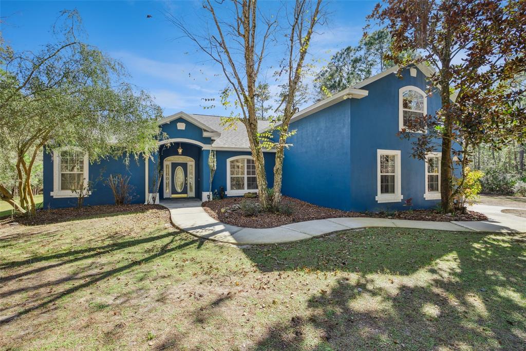 An aerial view shows a house with a swimming pool surrounded by dense forest — 3441 HICKORY CREEK ROAD, DELTONA, FL
