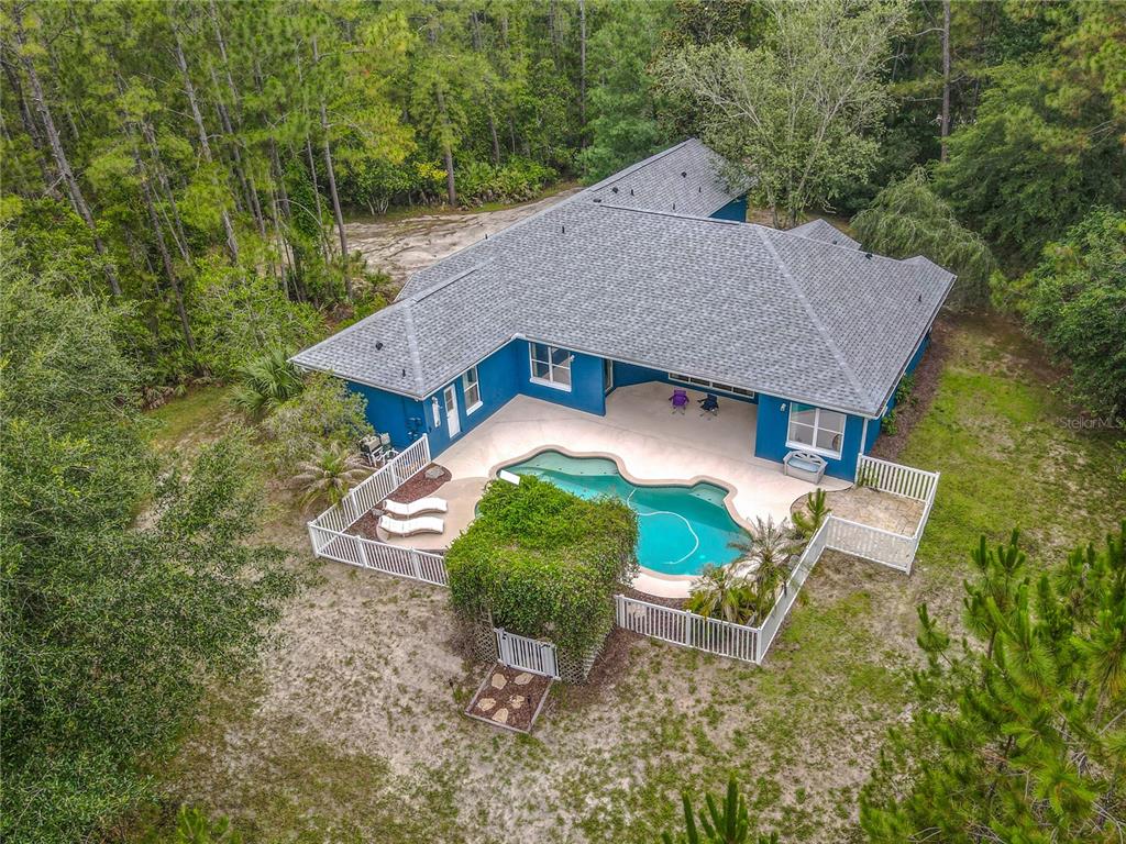 A blue, two-story house with white trim and a curved concrete walkway in the front yard — 3441 HICKORY CREEK ROAD, DELTONA, FL