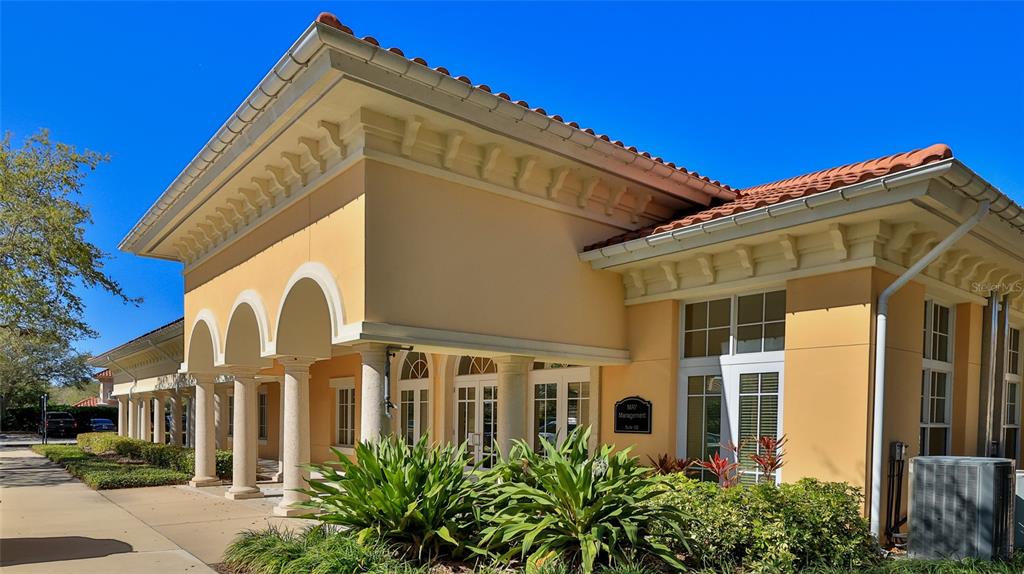 A tan commercial building with a tiled roof features a covered walkway with arched columns — 1 HAMMOCK BEACH PARKWAY, PALM COAST, FL