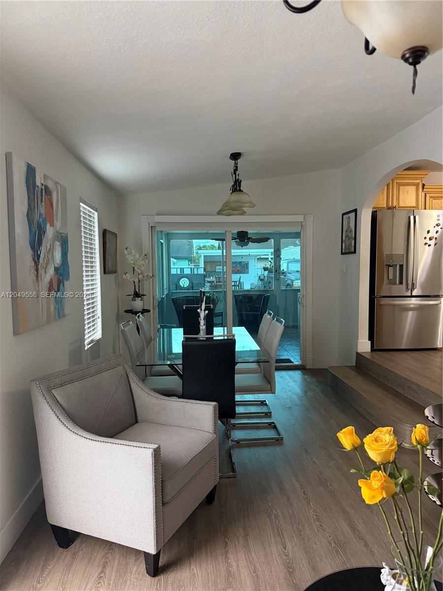 A dining area with a glass table and chairs sits adjacent to a living space — 2642 Atlantic Ave, Opa-Locka FL 33054, OPA-LOCKA, FL