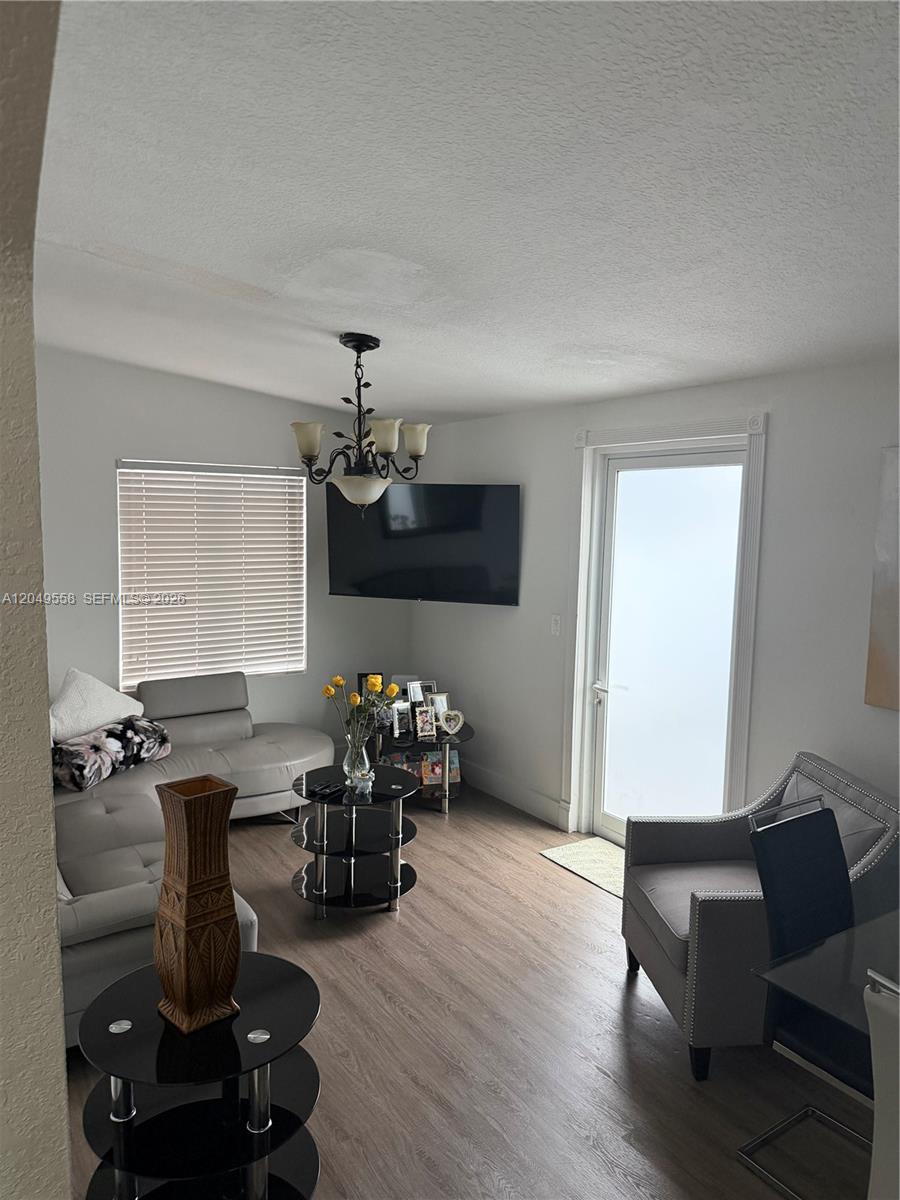 A living room features light gray furniture, a black tiered coffee table, and a chandelier — 2642 Atlantic Ave, Opa-Locka FL 33054, OPA-LOCKA, FL