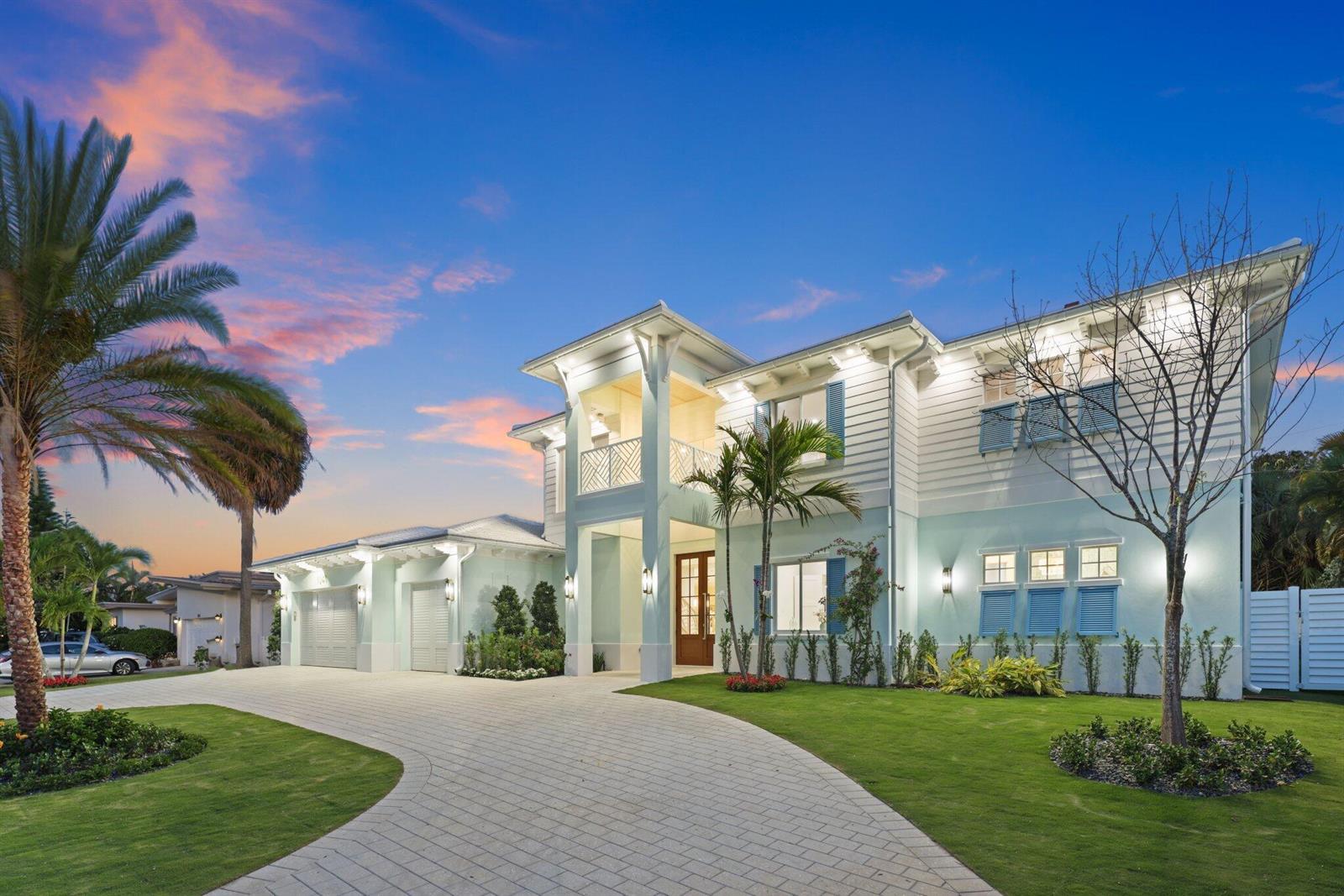 A two-story light blue house with a paved driveway, palm trees, and a front balcony — 1041 Bimini Lane, West Palm Beach FL 33404, WEST PALM BEACH, FL