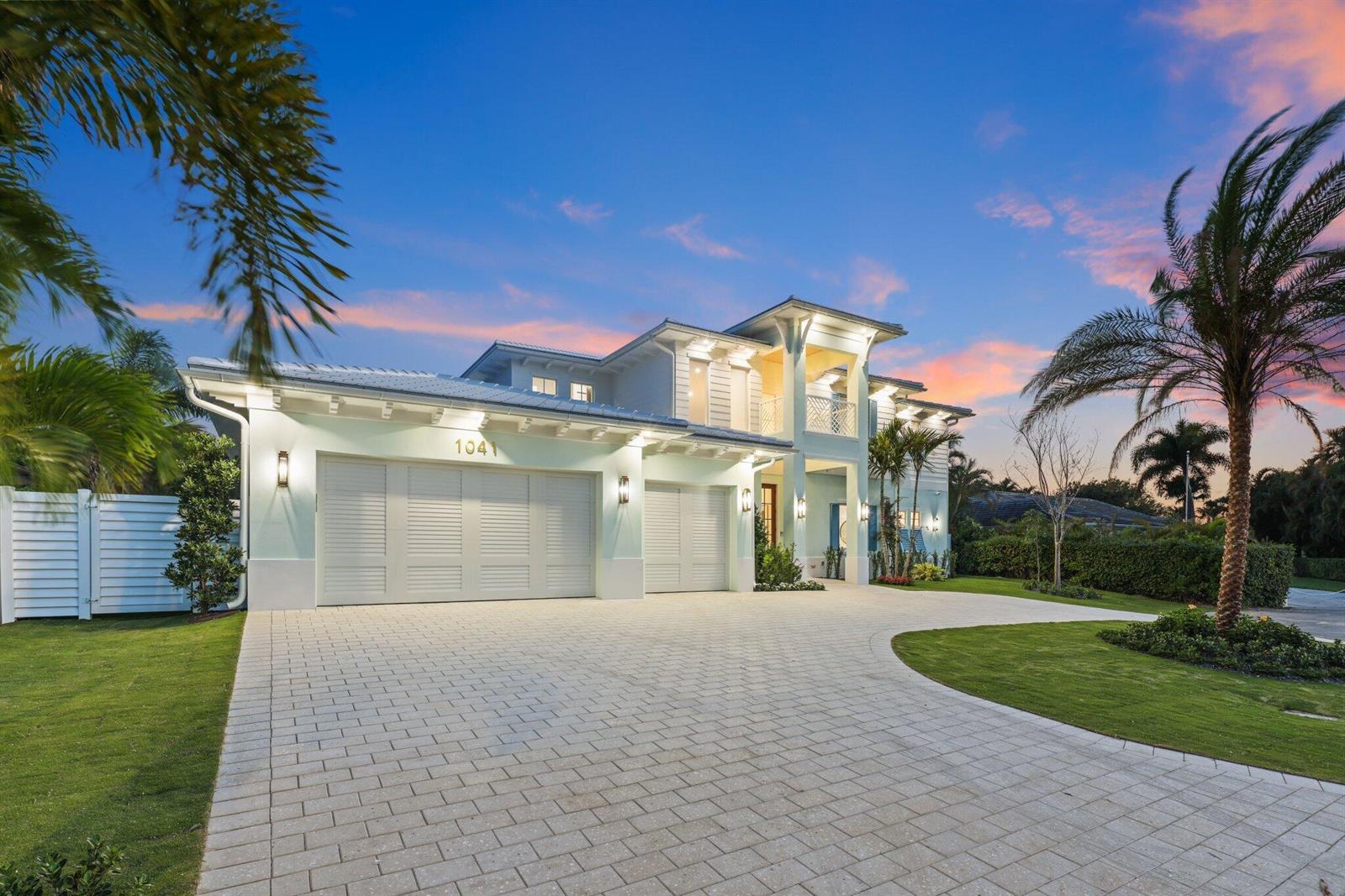A two-story house with a three-car garage and a paved driveway at sunset — 1041 Bimini Lane, West Palm Beach FL 33404, WEST PALM BEACH, FL