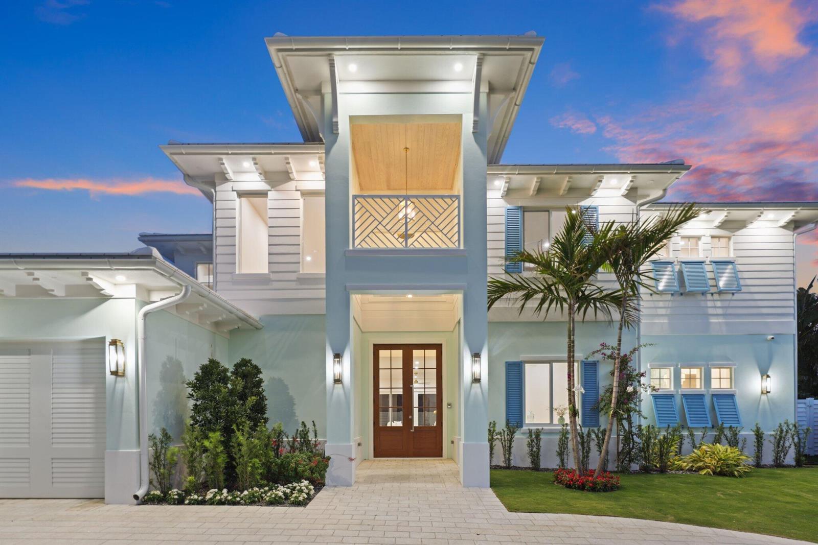 A two-story coastal home with light blue siding, a central balcony, and a paved driveway — 1041 Bimini Lane, West Palm Beach FL 33404, WEST PALM BEACH, FL