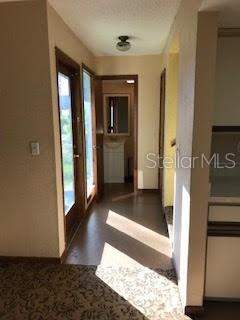 A hallway with patterned carpet leads toward a bathroom with a vanity and mirror — 431 W RICH AVENUE UNIT 429, DELAND, FL
