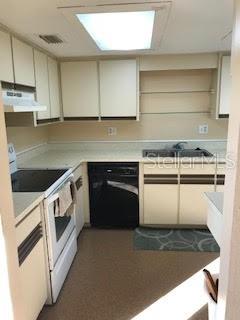 A kitchen features white cabinets, a black dishwasher, a white stove, and a skylight — 431 W RICH AVENUE UNIT 429, DELAND, FL