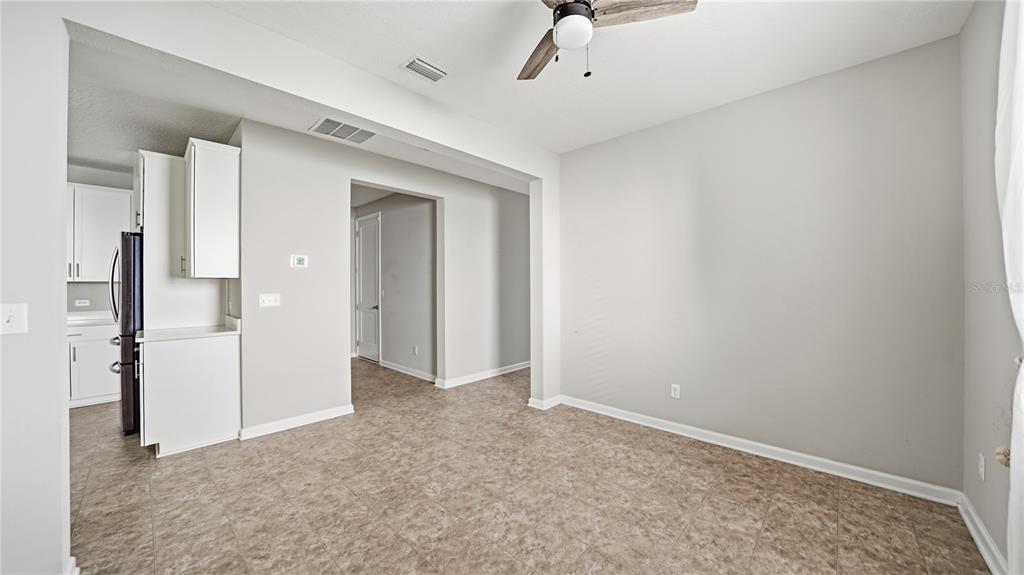 A dining area with tile flooring, a ceiling fan, and an adjacent kitchen — 1937 AMBERLY DRIVE, MIDDLEBURG, FL