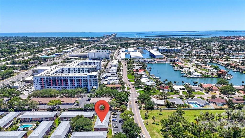 An aerial view shows a residential complex with a red location pin and nearby water — 4138 37TH STREET S UNIT 144, ST PETERSBURG, FL