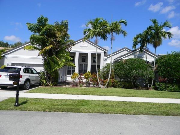 A white single-story house with a driveway, palm trees, and a parked SUV — 2721 W Abiaca Circle, Davie FL 33328, DAVIE, FL