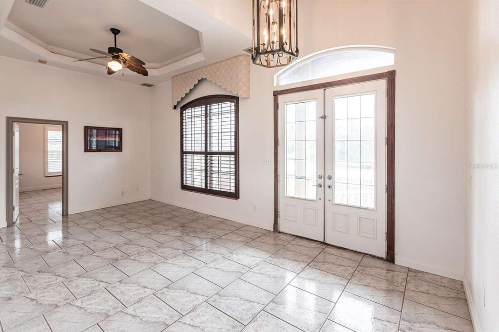 A bright foyer with tiled floors, a tray ceiling with a fan, and double entry doors — 3391 KNOX TERRACE, PORT CHARLOTTE, FL