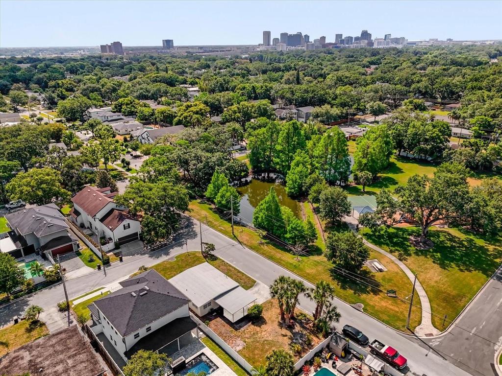 An aerial view shows a residential neighborhood with a small pond and a city skyline — 1600 HART LANE, ORLANDO, FL
