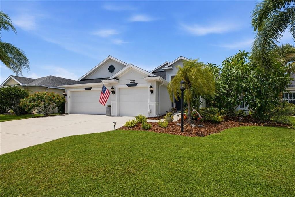 A covered patio features a dining area, outdoor kitchen, and a pool with a water feature — 4708 TILDEN PARK COURT, BRADENTON, FL