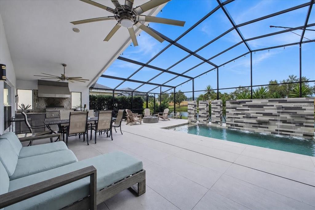 A modern kitchen with wood-toned cabinets, white countertops, and a hexagonal tile backsplash — 4708 TILDEN PARK COURT, BRADENTON, FL