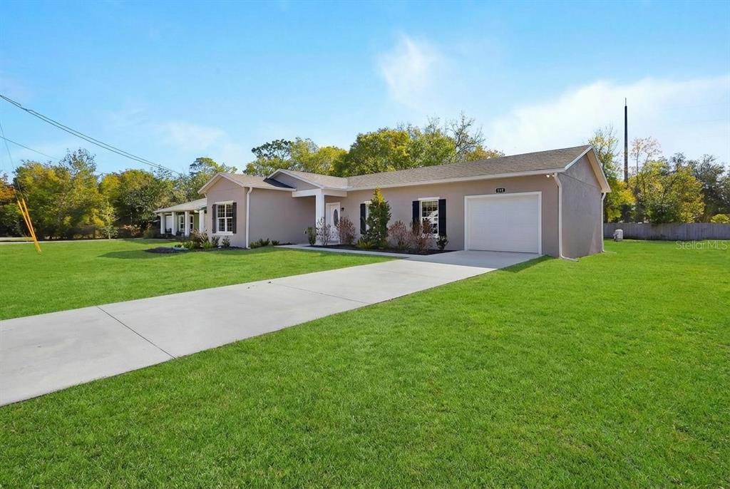 A single-story house with a beige exterior, a concrete driveway, and a one-car garage — 178 DOVER LANE, DELAND, FL