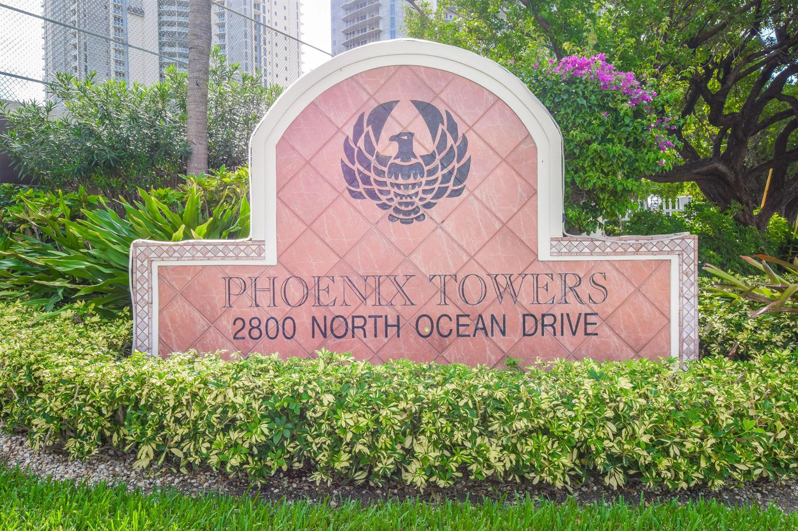 A sign for Phoenix Towers stands in front of lush landscaping and a tall building — 2800 N Ocean Drive # 8b, Singer Island FL 33404, SINGER ISLAND, FL