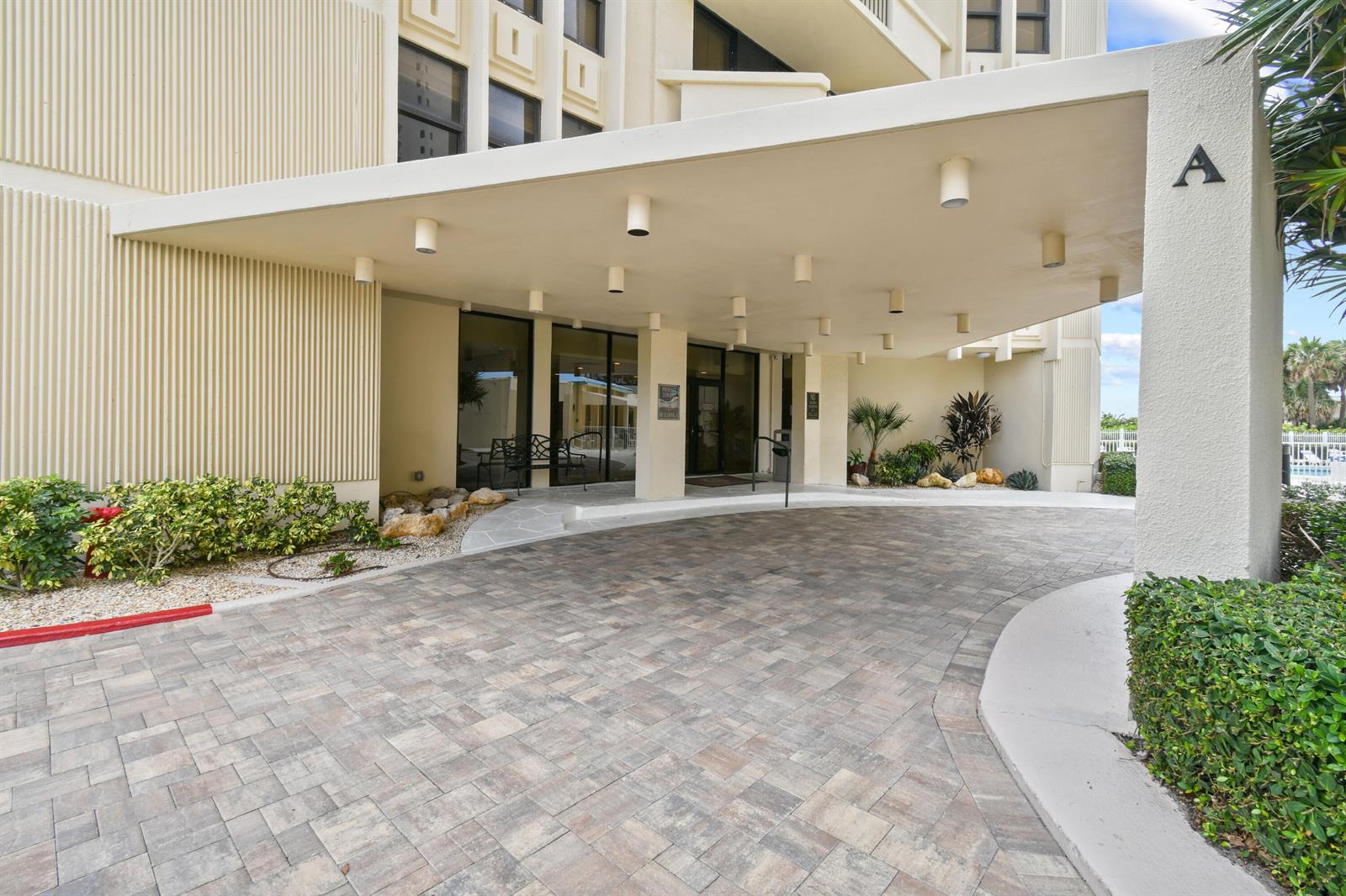A paved driveway leads to the covered entrance of a multi-story building marked with A — 2800 N Ocean Drive # 8b, Singer Island FL 33404, SINGER ISLAND, FL