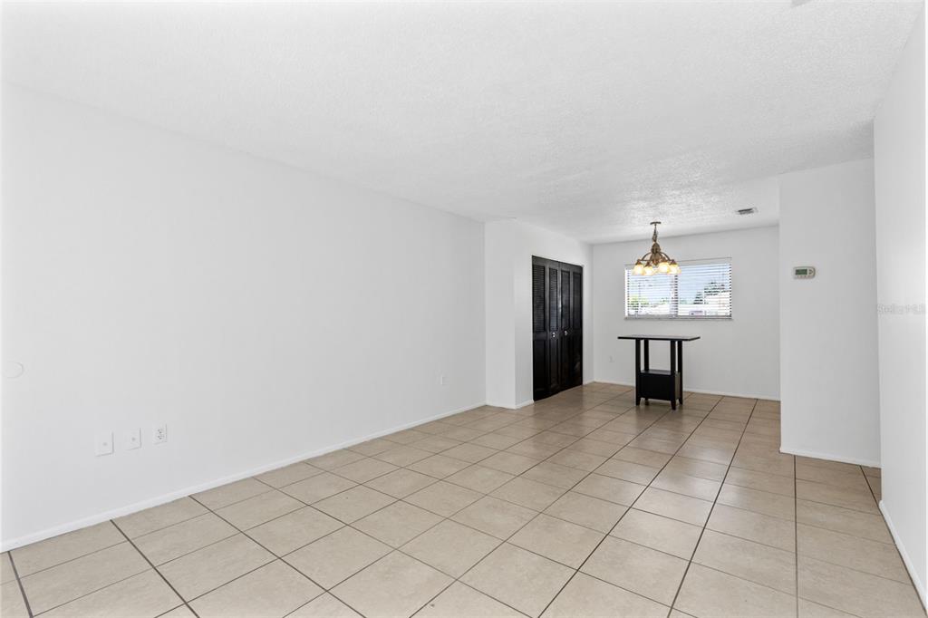 A bright, open-concept dining area features light-colored floor tiles, white walls, and a small table — 343 SAN MIGUEL STREET UNIT 343, WINTER SPRINGS, FL