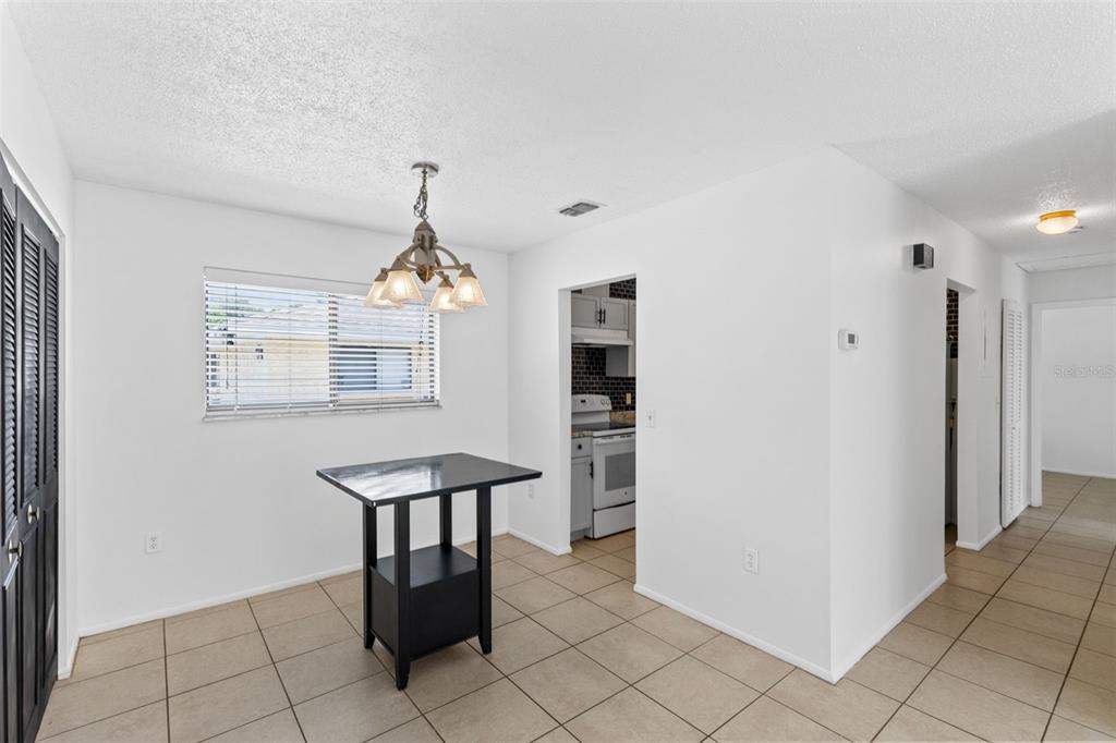 A dining area with a black table, tile flooring, and a view into the kitchen — 343 SAN MIGUEL STREET UNIT 343, WINTER SPRINGS, FL