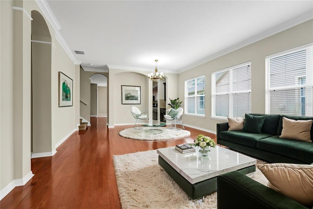 A living room features hardwood floors, a dark green sofa, and a white area rug — 12718 BIDEFORD AVENUE, WINDERMERE, FL
