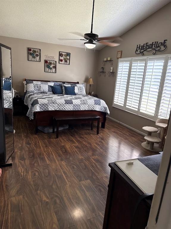 A bedroom features wood-look flooring, a ceiling fan, a bed with a quilt, and shutters — 2514 ABBEY AVENUE, ORLANDO, FL