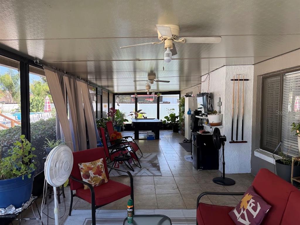 A covered patio features tile flooring, red patio furniture, a pool table, and ceiling fans — 2514 ABBEY AVENUE, ORLANDO, FL