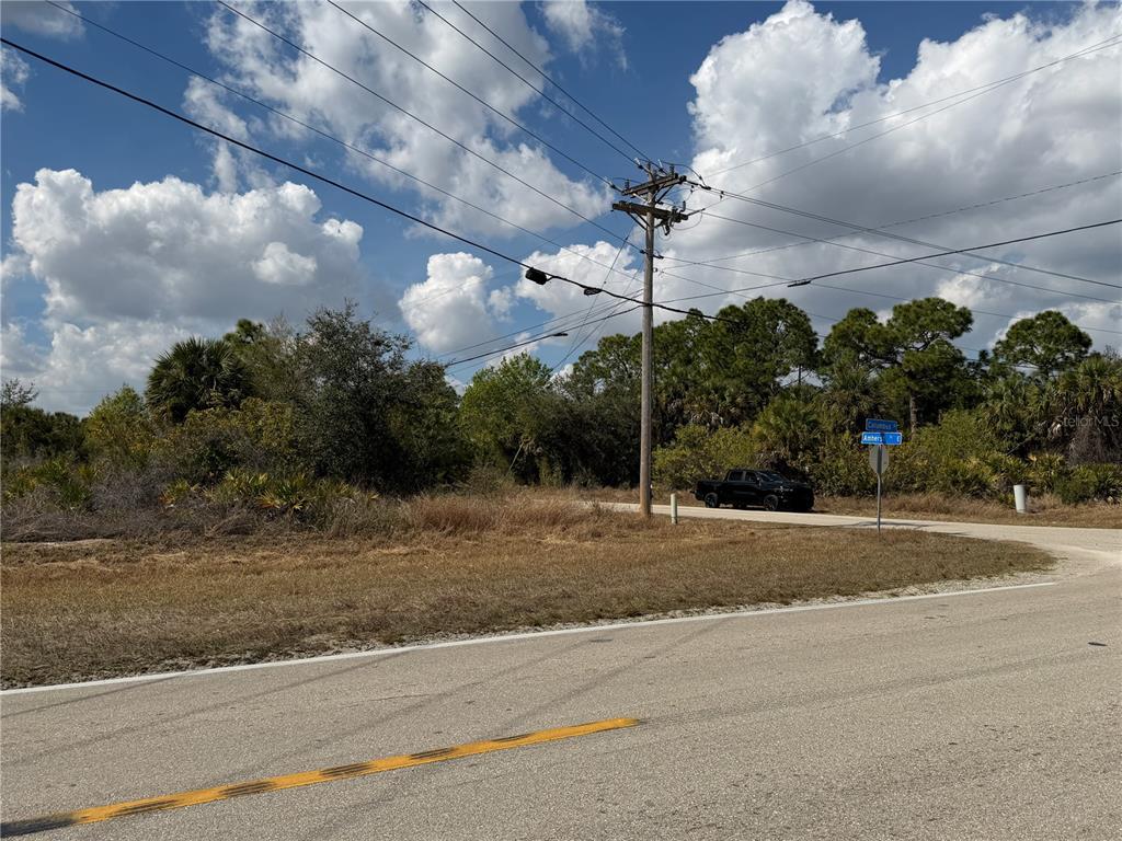 A utility pole stands at the corner of a paved road next to a vacant lot — 522 COLUMBUS BOULEVARD S, LEHIGH ACRES, FL
