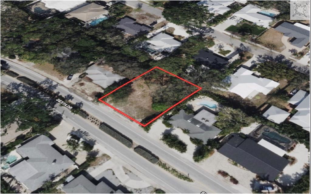 An aerial view shows a vacant, rectangular residential lot outlined in red along a road — 1871 SIESTA DRIVE, SARASOTA, FL