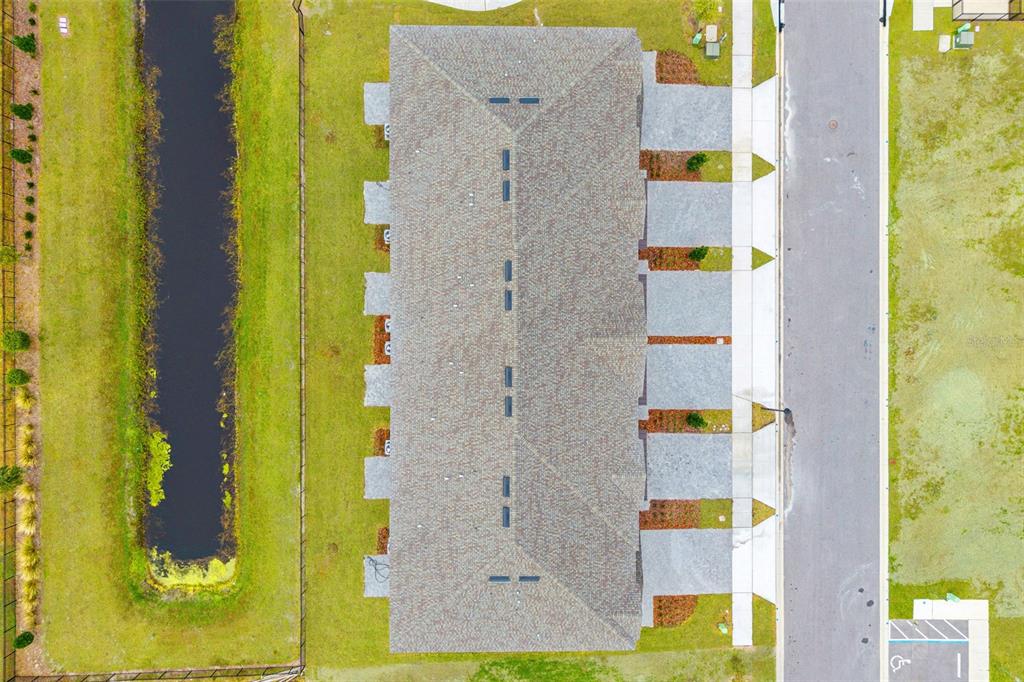 An aerial view shows a multi-unit townhouse building with a canal and a street — 1117 ORANGE TRAILSIDE WAY, OCOEE, FL
