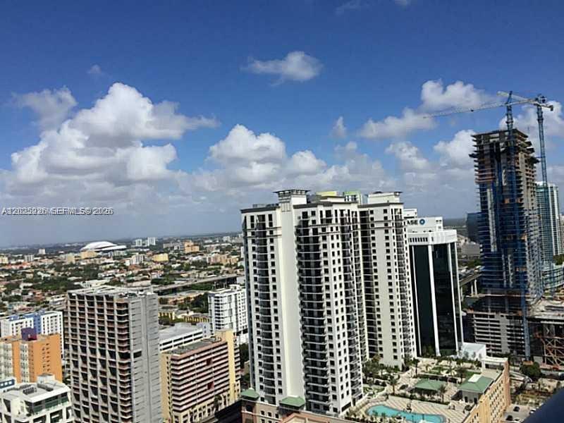 An aerial view shows several high-rise apartment buildings and a construction site under a blue sky — 1100 S MIAMI AVE # 3306, Miami FL 33130, MIAMI, FL