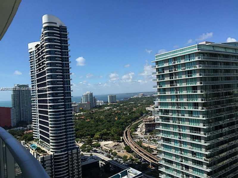 An elevated view shows two tall residential skyscrapers overlooking a green area and train tracks — 1100 S MIAMI AVE # 3306, Miami FL 33130, MIAMI, FL