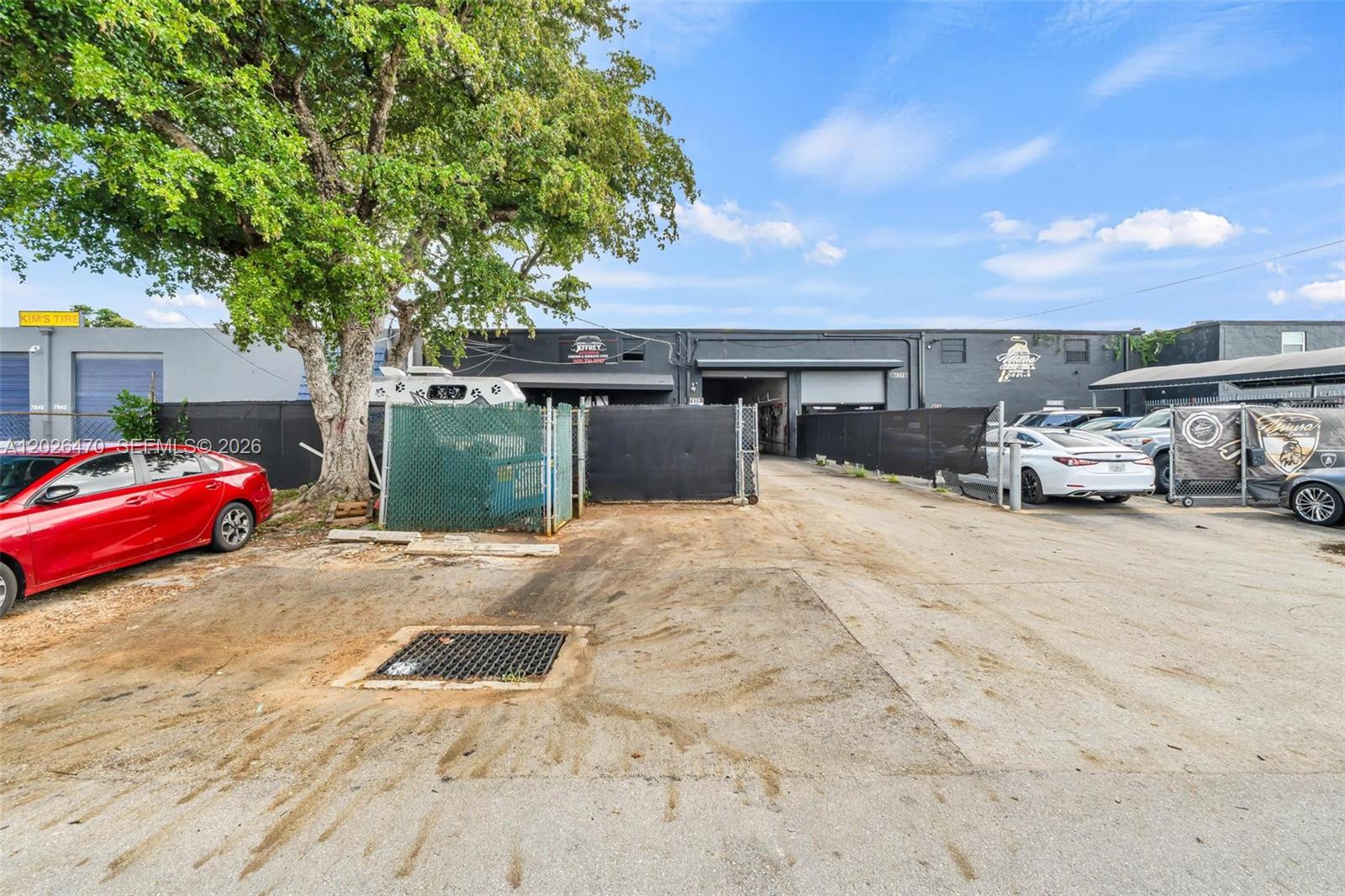 An exterior view shows a commercial warehouse building with a paved lot and chain-link fencing — 7850 NW 56th St, Doral FL 33166, DORAL, FL