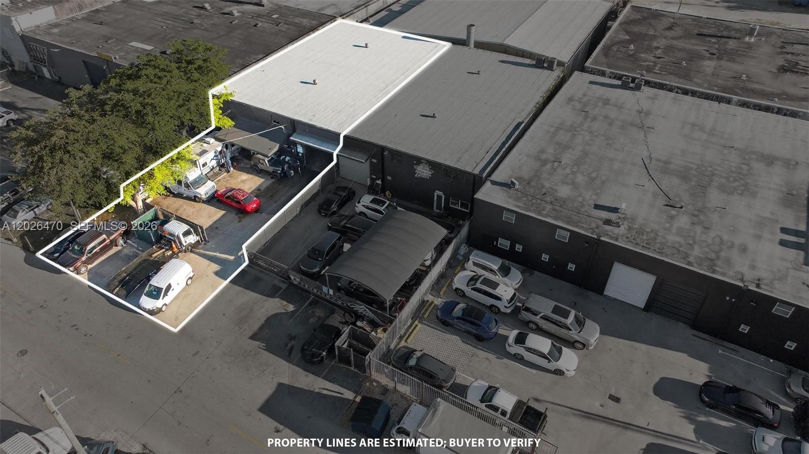 An aerial view shows a commercial warehouse building with an adjacent fenced parking lot — 7850 NW 56th St, Doral FL 33166, DORAL, FL
