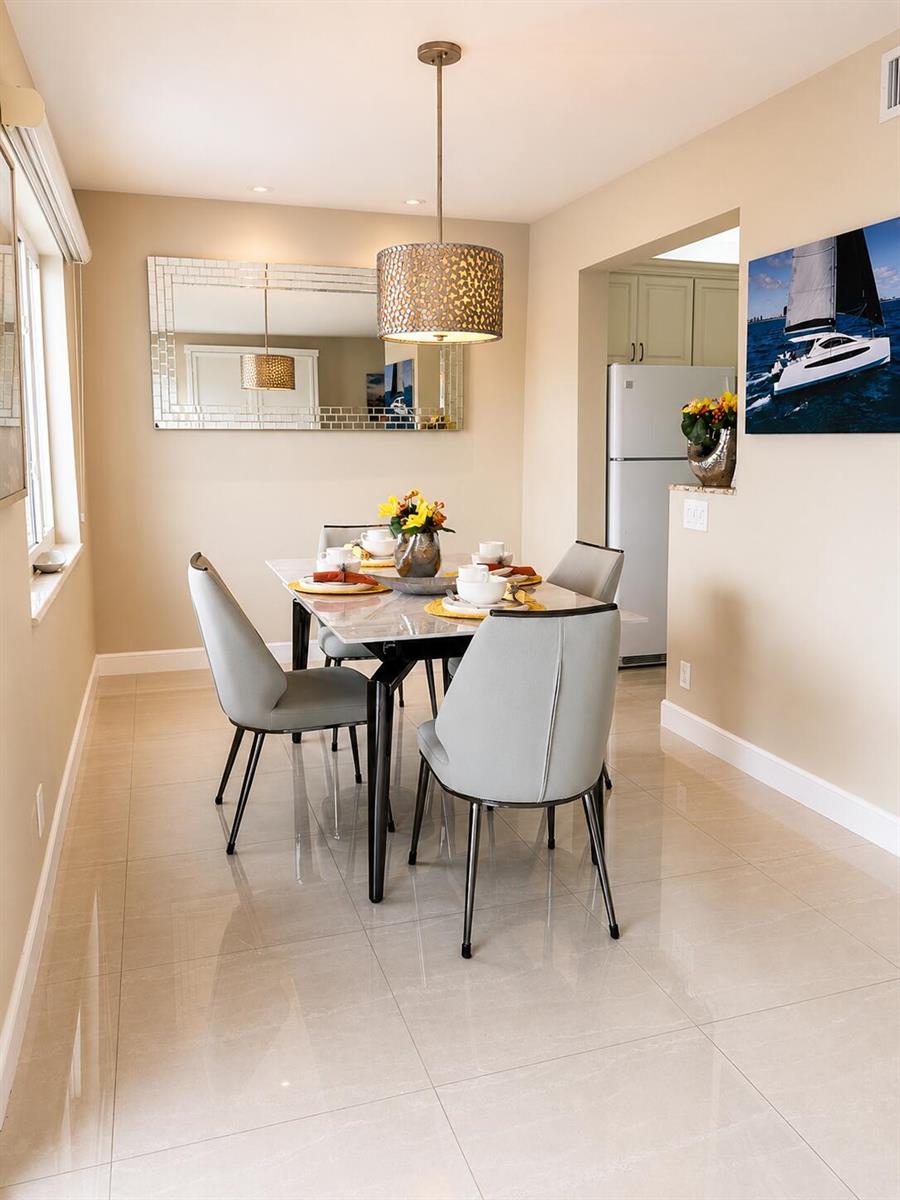 A dining room features a marble-topped table, four gray chairs, and a decorative pendant light — 1201 S Riverside Drive # 307, Pompano Beach FL 33062, POMPANO BEACH, FL