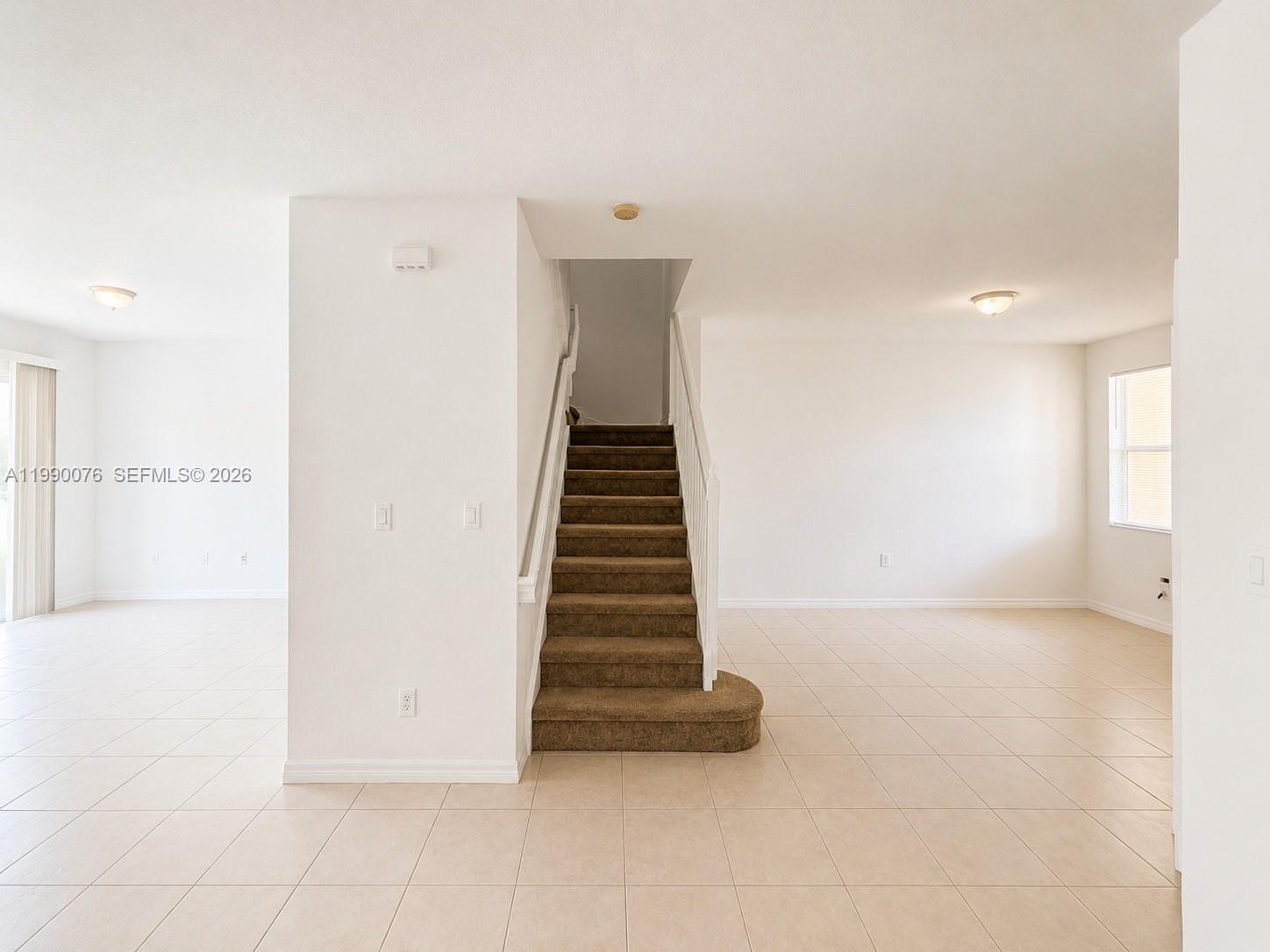An interior view shows a carpeted staircase centered between two tiled living areas — 16649 SW 80th Ter, Miami FL 33193, MIAMI, FL