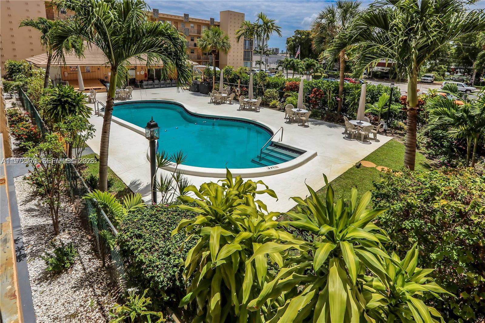 A white kitchen features a stove, refrigerator, and upper cabinets with a light countertop — 2145 Pierce St # 421, Hollywood FL 33020, HOLLYWOOD, FL
