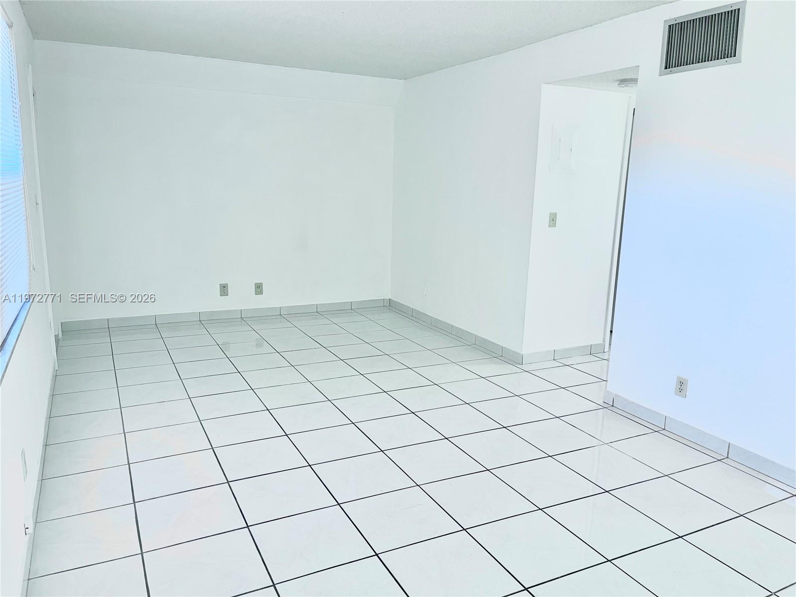 A small kitchen features white cabinets, a light green tiled backsplash, and white floor tiles — 2145 Pierce St # 421, Hollywood FL 33020, HOLLYWOOD, FL