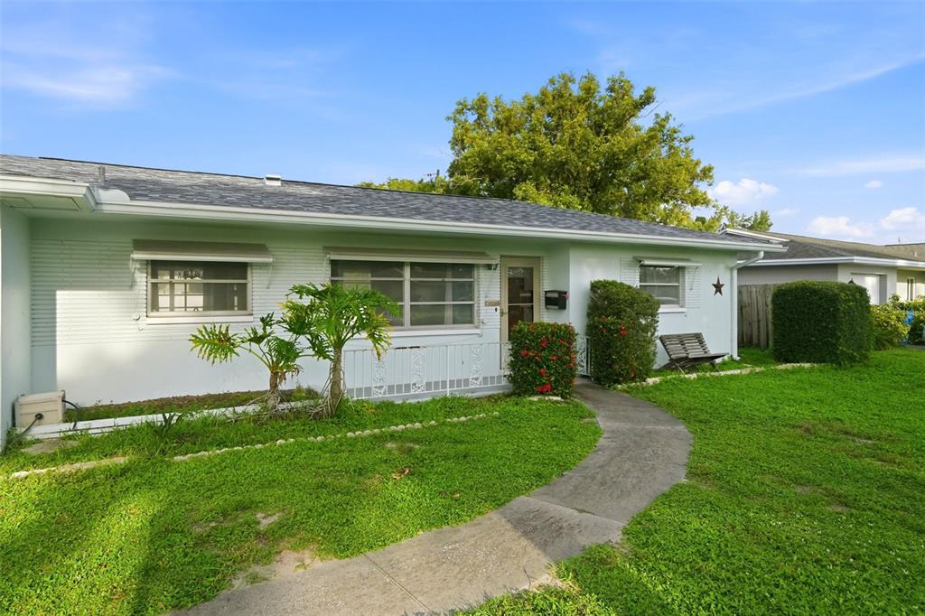 A single-story house with a light-colored brick exterior, a walkway, and a green lawn — 8835 109TH STREET, SEMINOLE, FL