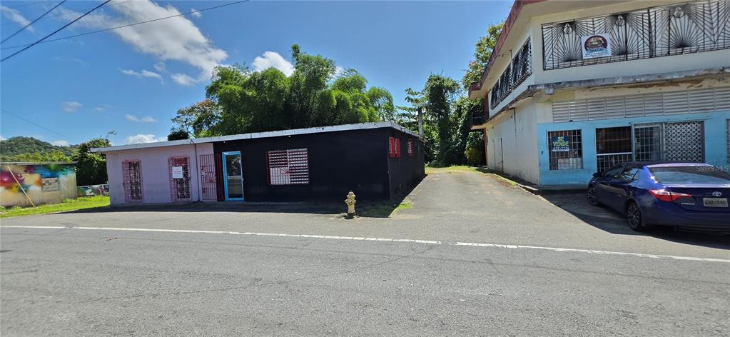 An exterior view of a single-story black building next to a two-story white building — Carr #160 W ALMIRANTE, VEGA BAJA, PR