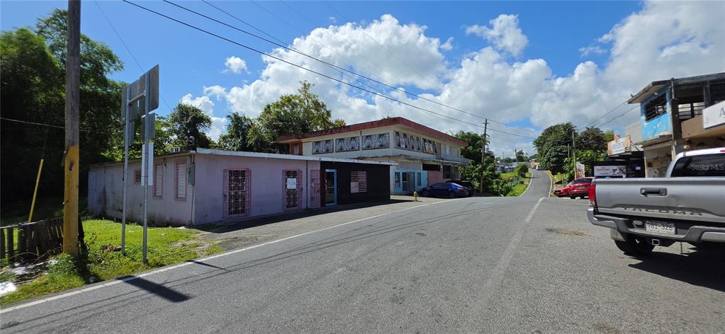 A street-level view shows a pink commercial building next to a two-story structure — Carr #160 W ALMIRANTE, VEGA BAJA, PR
