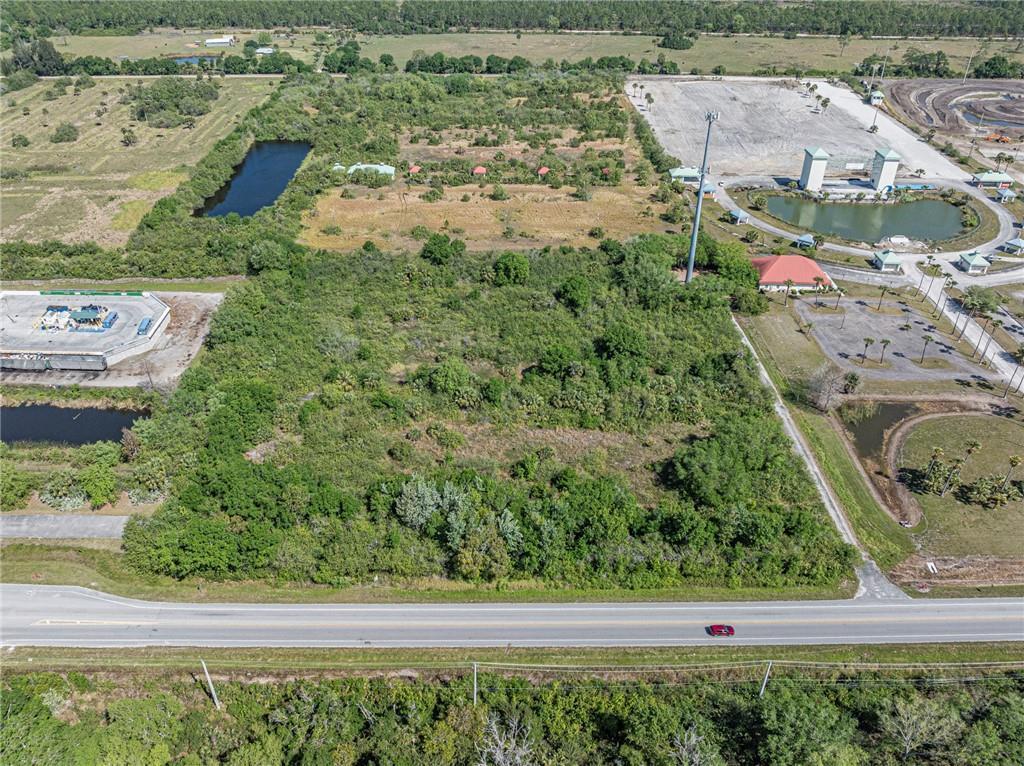 An aerial view shows a large, undeveloped wooded lot bordered by a road and commercial development — 0 Unassigned, Fellsmere FL 32948, FELLSMERE, FL