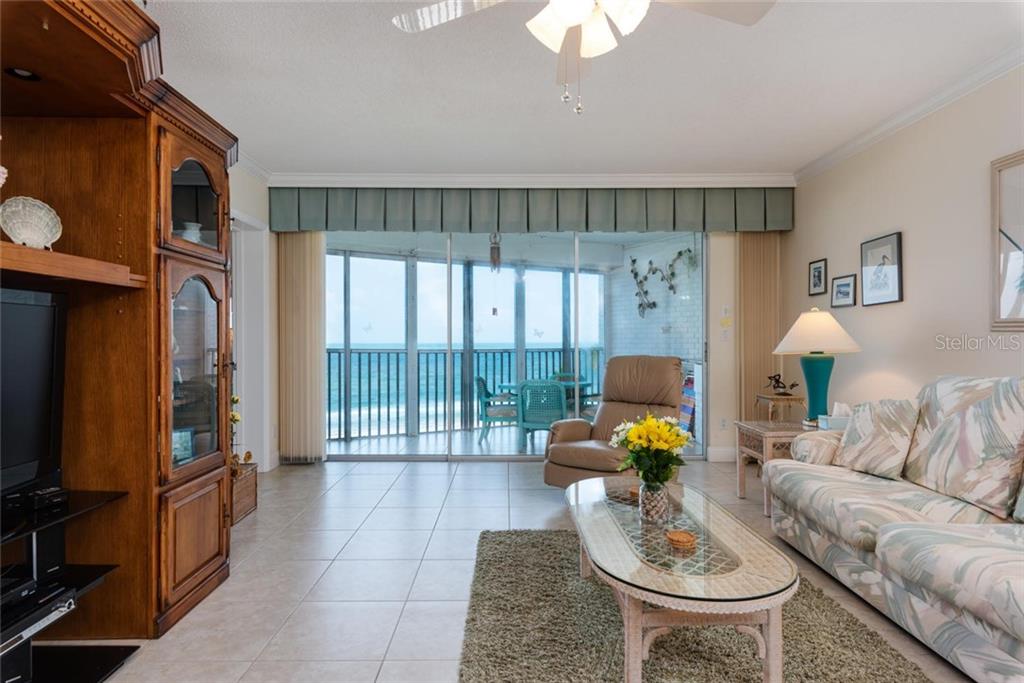 A living room with tile floors, a glass coffee table, and a balcony overlooking the ocean — 4825 GULF OF MEXICO DRIVE UNIT 605, LONGBOAT KEY, FL
