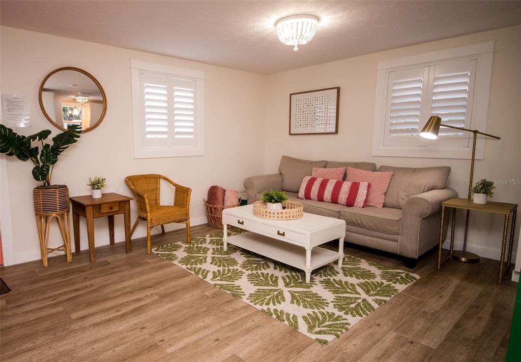 A living room features a beige sofa, a white coffee table, and a patterned rug — 1805 IVANHOE STREET, SARASOTA, FL