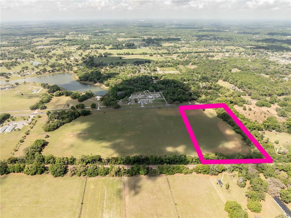 An aerial view shows a large, rectangular plot of land outlined in bright pink — 0000 S US HIGHWAY 301 HIGHWAY, SUMMERFIELD, FL