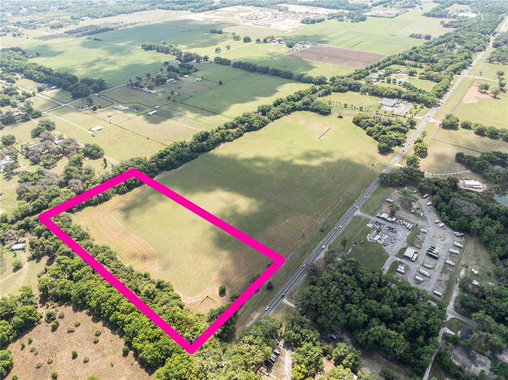 An aerial view shows a rectangular plot of land outlined in pink beside a road — 0000 S US HIGHWAY 301 HIGHWAY, SUMMERFIELD, FL