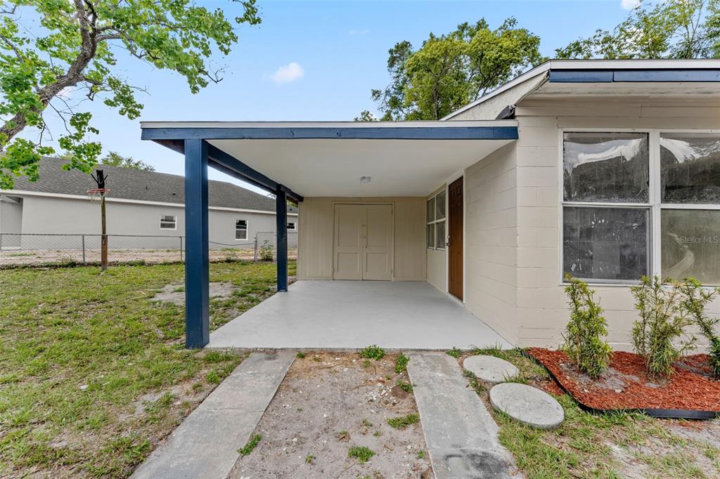A single-story house sits on a large, grassy lot surrounded by mature trees — 1218 CRESCENT STREET, SANFORD, FL