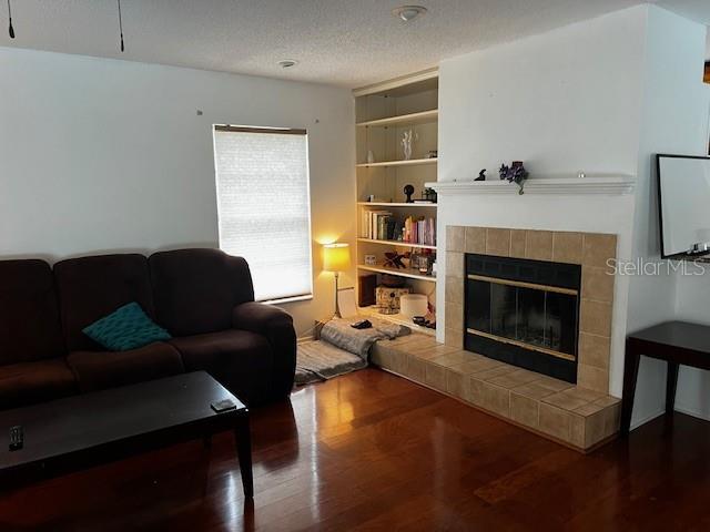 A living room features a brown sofa, a fireplace with tile surround, and built-in shelving — 18330 CYPRESS VIEW WAY, TAMPA, FL
