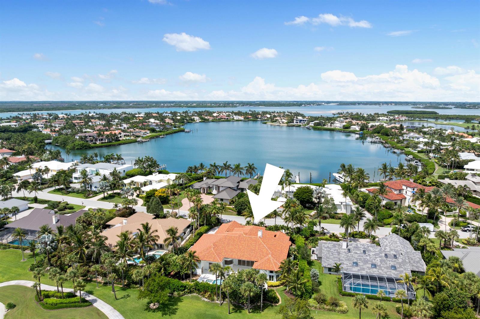 An aerial view shows a house with a red tile roof near a large lake — 6841 SE Harbor Circle, Stuart FL 34996, STUART, FL